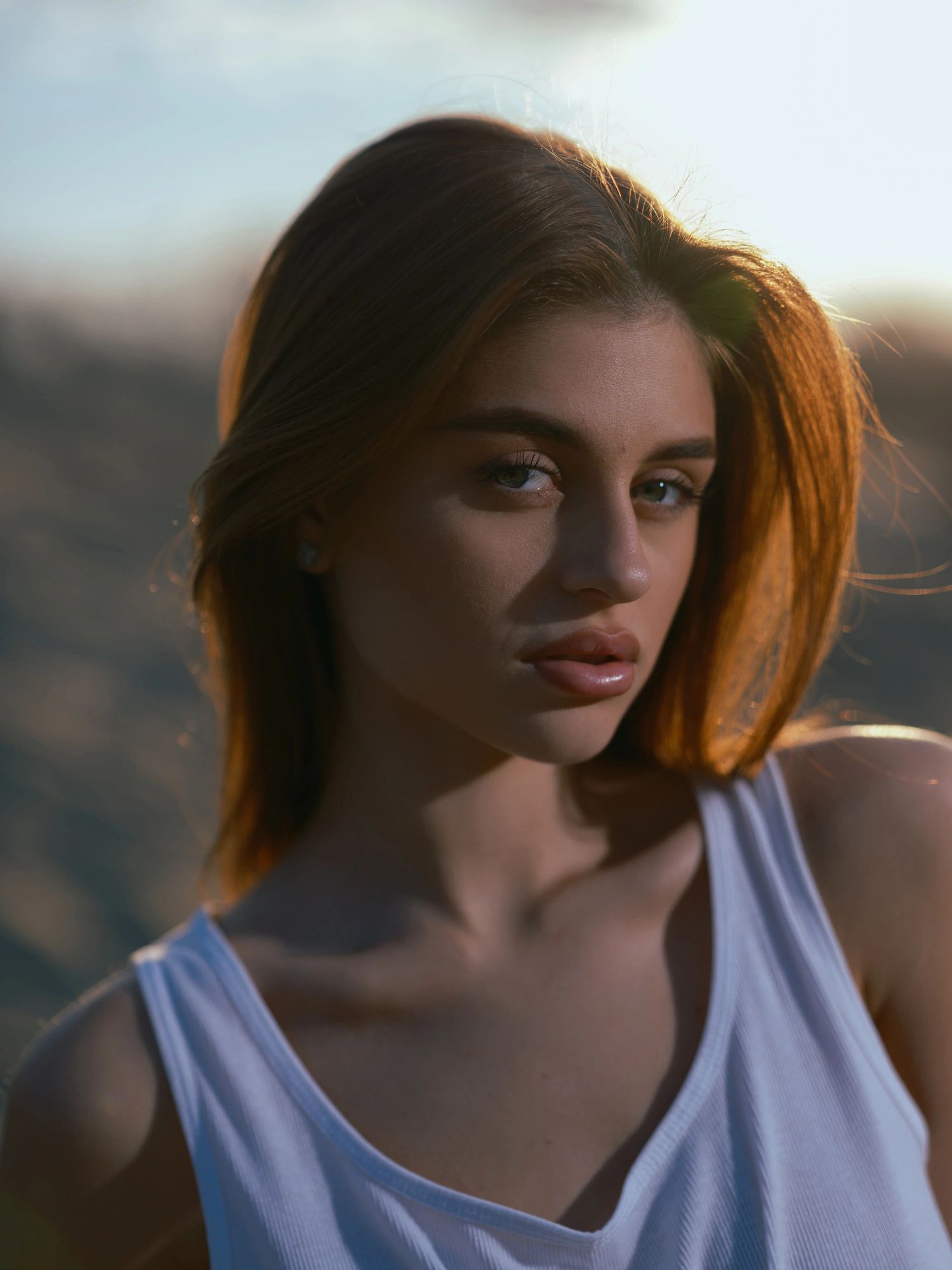 Portrait of a woman outdoors at sunset with a reflective mood